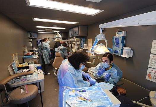 Caption: Three dental chairs keep busy with patients inside a specially equipped recreational vehicle operated by the Tzu Chi Me