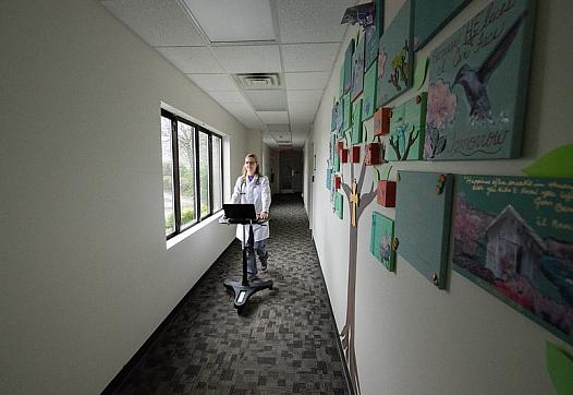 Physician walks down hallway