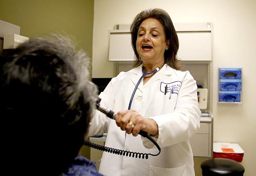 Dr. Elyzabat Tadros examines Elizabeth Torino at Kaiser Permanente medical offices.