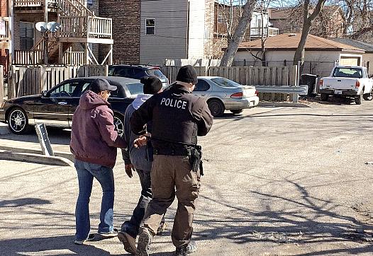 Chicago police officers take a heroin buyer into custody on West Flournoy Street in Chicago. 