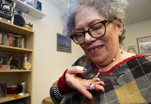 Rita Daley shows off a necklace she made: “The world views me as insane,” she said. At the center, “instead of calling me crazy,