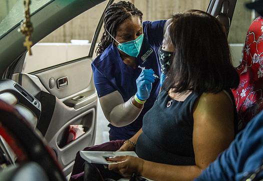  Amaka Iheaka gives a shot to Yolanda Penaflor at a COVID-19 vaccination clinic at the Long Beach Convention Center on April 1, 