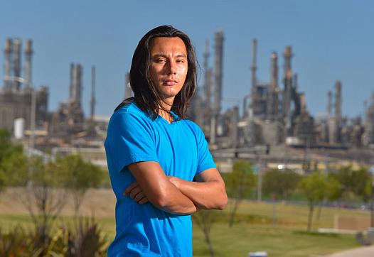 With the ConocoPhillps refinery behind him, Nick Serrano stands in the Wilmington Waterfront Park in Wilmington on Friday, Aug. 