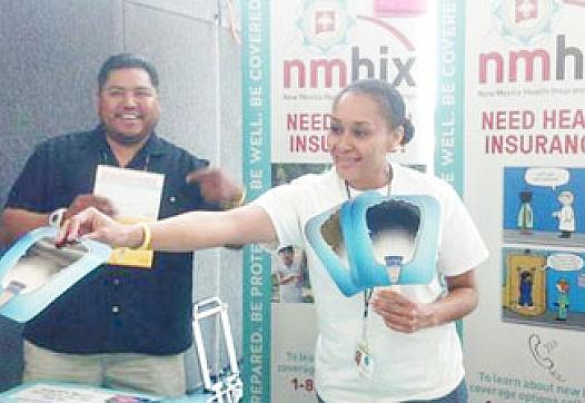 Antwhan Yazzie, left, and Monica Marthell, staffers for the Native American Professional Parent Resources (NAPPR) in Albuquerque, N.M., hand out fans at an outreach booth. Both were working a public event to generate awareness for the Affordable Care Act. (Photo courtesy of NAPPR)