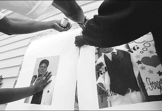 Friends of Ditiyan Franklin, 17, place posters of him Thursday at the site of his killing in Oakland. Franklin, a senior about t