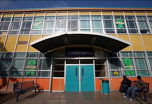 Students sit in front of Castlemont Business Information Technology School in Oakland, Calif.