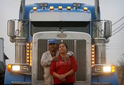 Jose Rodriguez and his wife, Maria, with their truck near their home in Jurupa Valley. The family makes a living moving goods around the nation.