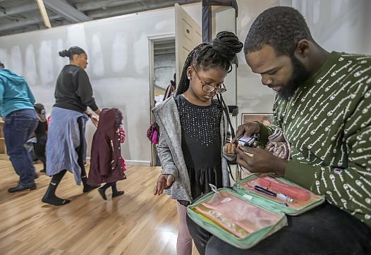Chris Stewart, right, checks the blood sugar levels of his daughter, McKenzie Stewart, 6, center, after her jazz dance class