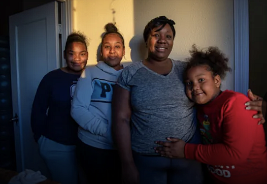 Tanya Harris and her daughters stand inside their restroom for a portrait on Feb 04