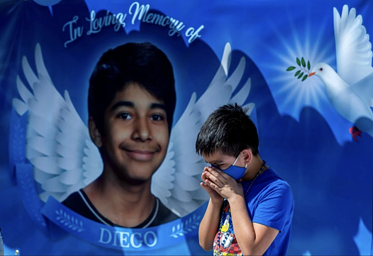 Eric Henry, a 9-year-old Moreno Valley boy, prays in front of a memorial for Diego Stolz