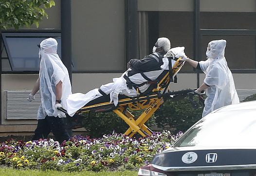 A nursing home resident is wheeled on a stretcher from an ambulance into the Canterbury Rehabilitation and Healthcare Center
