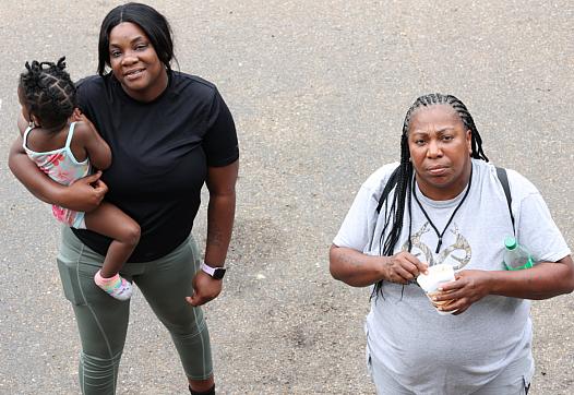 Jasmine Sandifer, left, whose mother is a resident at Sunset Village, and Doris Williams, right, wait outside their motel rooms 