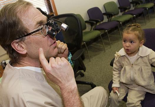 Dr. Dwight Jones talks about teeth with his young patients, including Seeanna Floyd, 2, at the children’s dental clinic.
