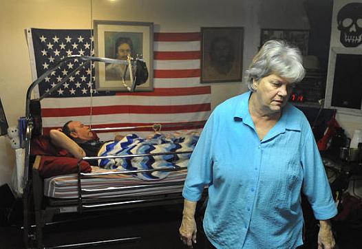 Shirley Ropka gets her son, Chuck, ready for bed at her house in Parkville. Chuck has lived in the basement of the family house ever since he was shot when he was younger.