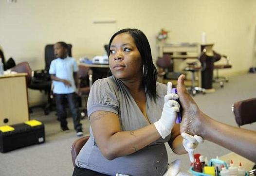 Kanitra Patterson, with her son Robert Jr., age 6, giving a pedicure at Highland Nails in Highland Park. Kanitra Patterson developed a serious heart condition while pregnant with Robert. Doctors said she faces a 50 percent risk of death if she developed that same condition during her current pregnancy. (David Coates / The Detroit News)   