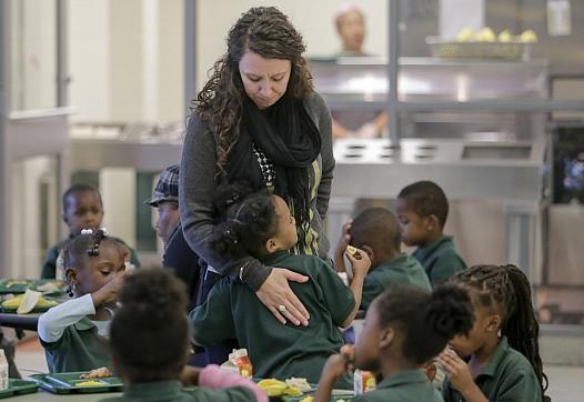 Lawrence D. Crocker College Prep counselor Rochelle Gauthier gets a hug from a student during lunch at the school in New Orleans