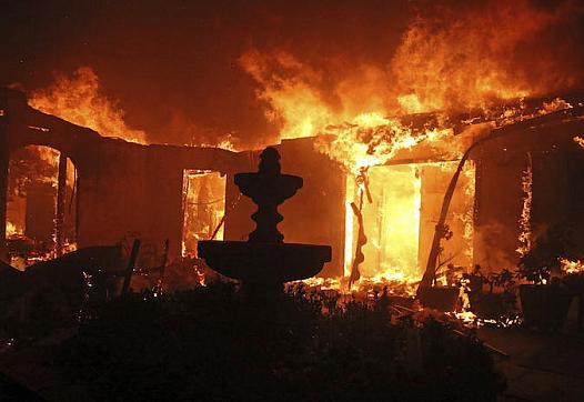 A home is consumed by the Woolsey Fire in Malibu, Calif., on Friday, Nov. 9, 2018.