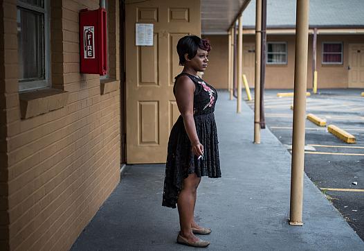 Ashley Peterson smokes a cigarette just outside of her Airway Motel room in Atlanta.