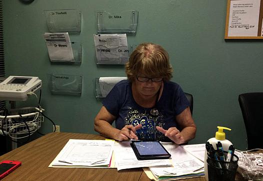 Donna Armes, director of The Haley Center in Winter Haven works on a patient's chart.