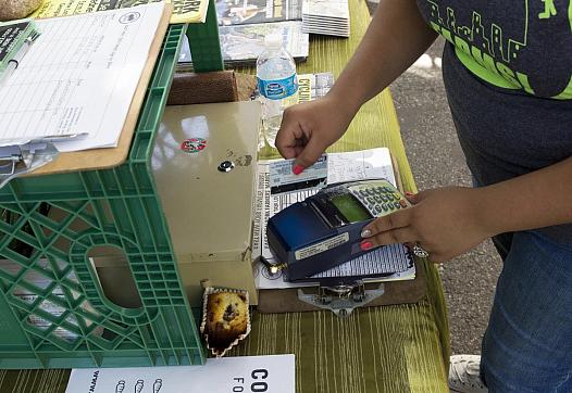A customer swipes an EBT card at a farmers' market in New York City. Andrew Lichtenstein / Corbis via Getty Images file