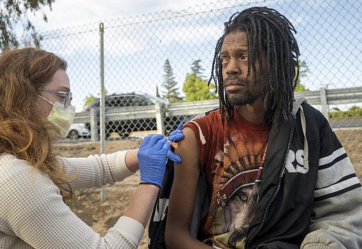The Community Lead Advocacy Program (CLAP) brought vaccines to a homeless encampment in the Valley Hi area. Javon Coleman was am
