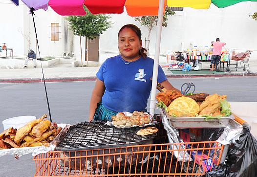 Carolina stands behind a homemade food cart at the Guatemalan Night Market in the Westlake neighborhood of Los Angeles.