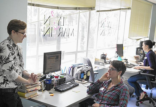 Front office manager Cameron McCaugherty, left, confers with nurse practitioner Heather Rowley at Lyon-Martin Health Services in San Francisco, which serves many low-income patients. The city is struggling to balance its desire to provide healthcare to all residents against its desire for people to sign up for Obamacare. (David Butow / For The Times)