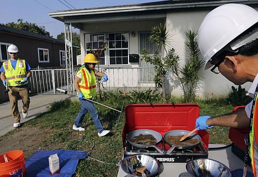 Bharat Dungrani, an environmental health specialist for the L.A. County Health Dept, removes moisture from soil samples collecte