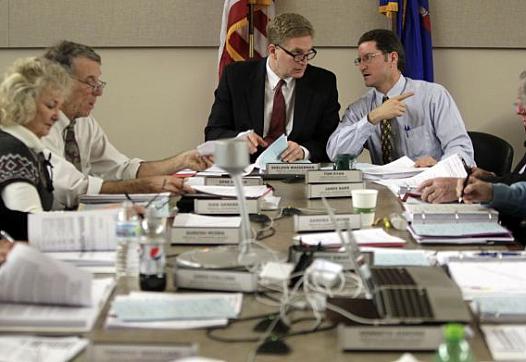 Dr. Sheldon Wasserman, center, chairman of the Wisconsin Medical Examining Board, talks with Tom Ryan, right, executive director of the board. On the left are board members Jude Genereaux and Dr. Gene Musser. The 13-member board, appointed by the governor, includes 10 doctors and three public members.  