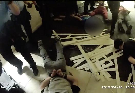 This screenshot of body camera footage shows police handcuffing teenage boys during a riot at Red Rock Canyon School on April 28