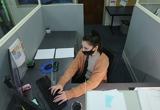 Brittany Irby, a state child abuse hotline operator, works on abuse reports at her workstation