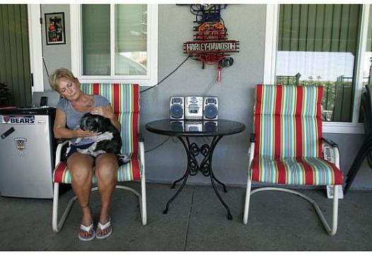 Mary Buffum, 65, of Fontana sits with her dog, Cash, next to her late husband Jack's chair on the patio where they loved to entertain family and friends. Jack Buffum, 59, was killed May 30, 2013, in a workplace accident in Rialto.