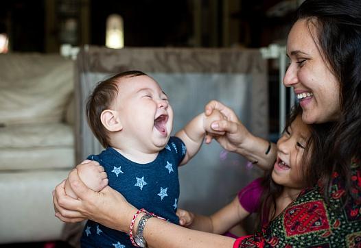 Tameka Issartel and her daughter Nalani, 5, laugh with Tenshin, 7 months, in their El Sereno living room