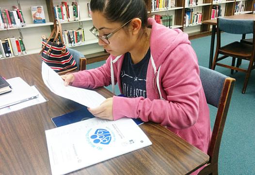 DACA recipient Stephanie Martinez reviews the Medi-Cal documents she received by mail. (EGP photo by Jacqueline Garcia)