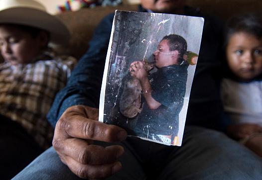 Hugo Secundino, 42, holds a weathered picture of his deceased son Angel.