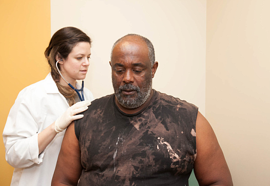 Dr. Samantha Smith checks on 58-year-old patient Paul Shelton. He has severe liver scarring as a result of hepatitis C, but his