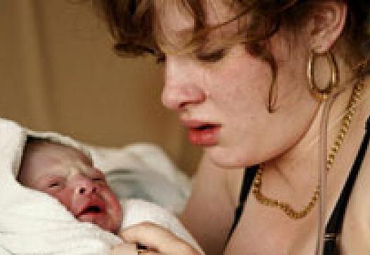 A teen mother who spent most of her life in foster care holds her newborn.