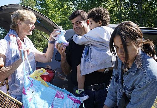 Janet McFetridge gives stuffed animals and snacks to a Palestinian family from Gaza as they collect their belongings from the ba