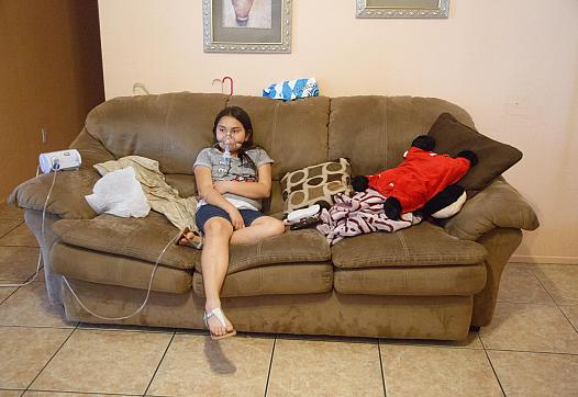 Kaylee Pineda uses a nebulizer treatment to prevent an asthma attack before going to her baseball game.