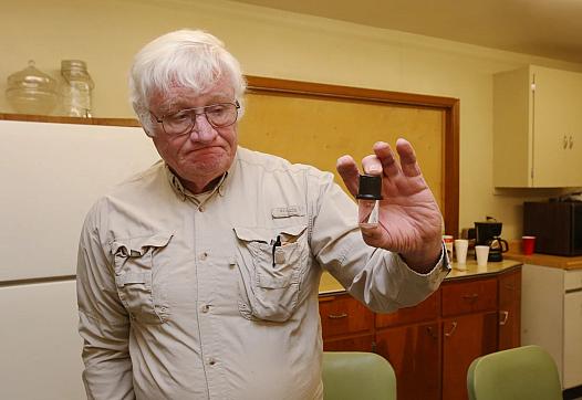 Mike Matthews holds a vial he uses when testing for nitrate in water on December 1. Each test costs $16. There are 37 reverse os