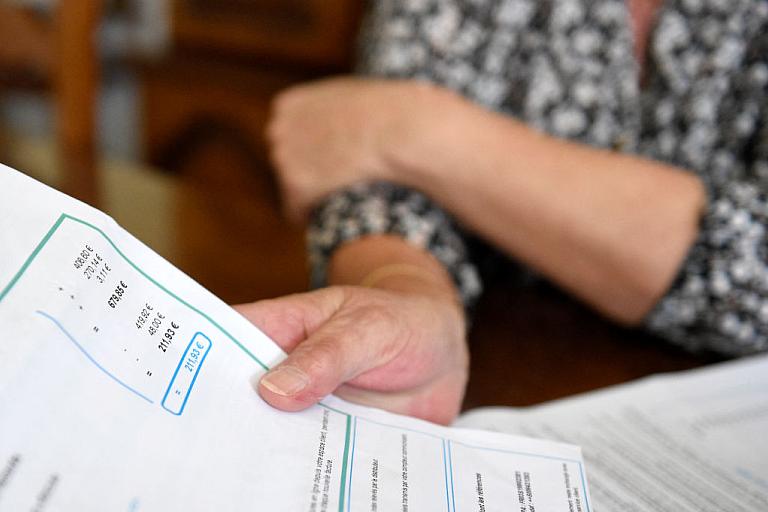 A woman holds a bill.