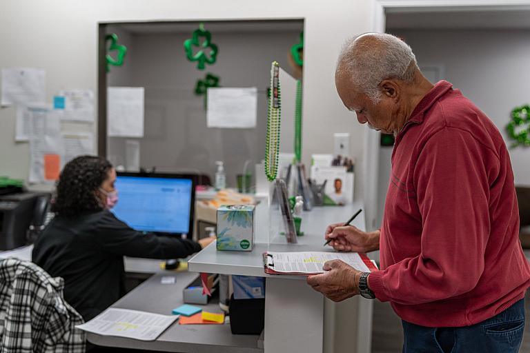 A man fills out paperwork at the doctor's office.