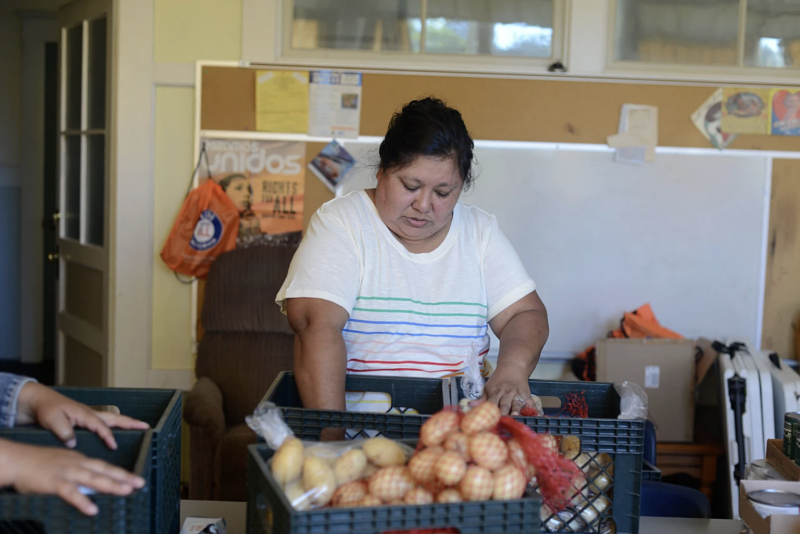 Diana Gómez Martínez clasifica las donaciones de alimentos para su entrega el 23 de junio de 2021. Diana Gómez Martínez hace saber a los trabajadores agrícolas que las promotoras han llegado el 23 de junio de 2021. Dana Ullman / The Mendocino Voice