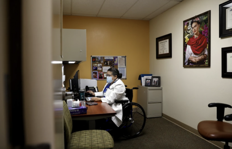 Dr. Marie Flores, working at her desk at AltaMed, says that, for her, “identifying as a woman is wanting to be a mother. When people judge you and question your ability to do that, it’s very, very hurtful.” (Christina House / Los Angeles Times)