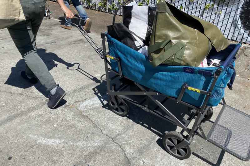 An outreach worker with Punks With Lunch pulls a handcart with sterile supplies in West Oakland / Ariel Boone