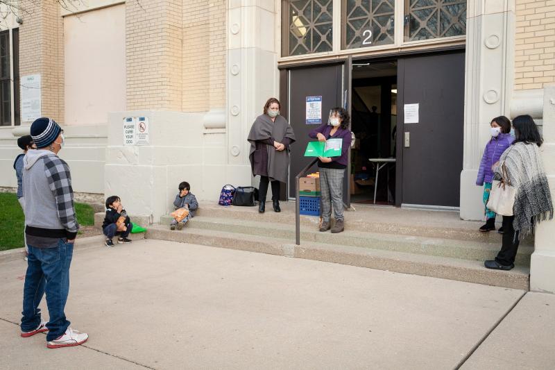 Contreras talks to parents and students outside of school on a November afternoon. She urged parents to take an active role in helping their kids during remote learning. Michelle Kanaar / WBEZ