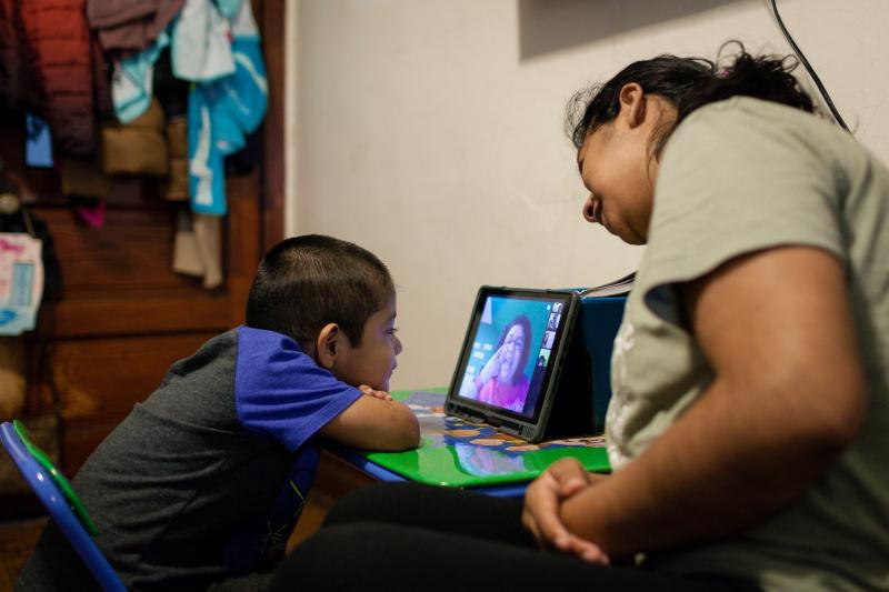 Sarai Camarillo supports her 4-year-old son, Isaac Ayala, for his daily hour of remote learning. Camarillo quit her job at a bakery so she could help her kids as they learn from home. Michelle Kanaar / WBEZ