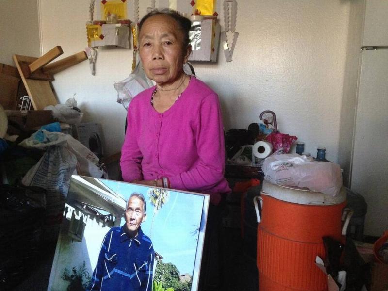 Tong Cha holds a photo of her husband, Her Xa Lor, who died in January 2016 of complications from respiratory failure and pneumonia after falling ill when heat was turned off at Summerset Village Apartments in Fresno in November 2015. BONHIA LEE