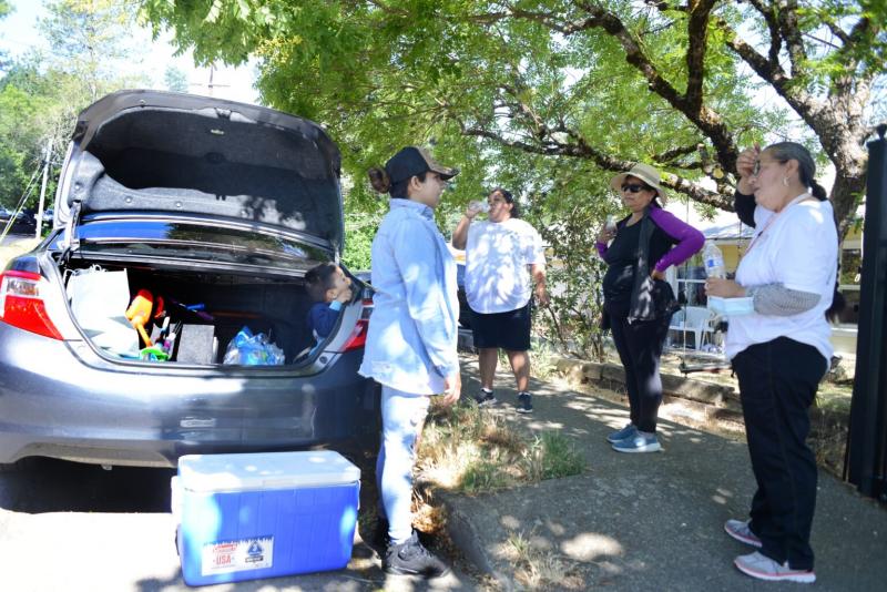 Lucy Tafoya (left), a promotora, hands out water and talks with fellow promotoras Diana Gomez Martinez, Chela Botello and a participant at the ‘10,000 Steps’ event in Willits on June 26 2021. Dana Ullman / The Mendocino Voice