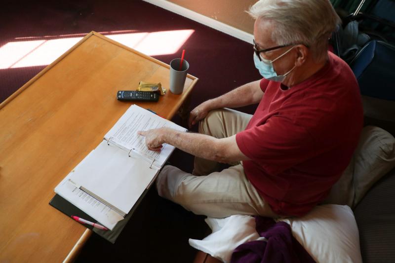 Lee Fournier sorts through a binder with potential housing options in his hotel room provided by Project Roomkey on Sunday, October 11, 2020, at Rodeway Inn & Suites in Indio, Calif. Project Roomkey is an effort by the state to house individuals experiencing homelessness during the COVID-19 pandemic. VICKIE CONNOR/THE DESERT SUN